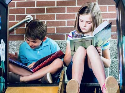 Boy and Girl Reading at the top of a slide